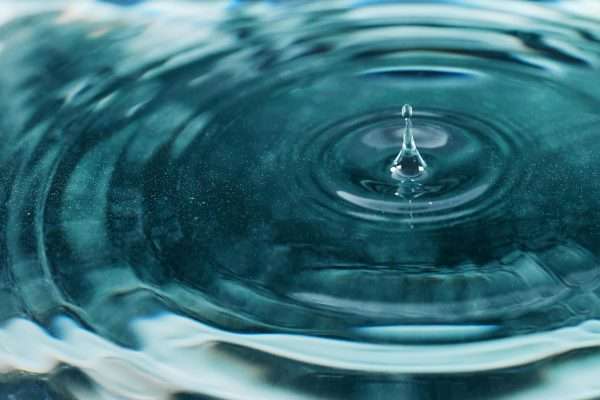 A mesmerizing close-up image of a water droplet creating ripples on the surface.