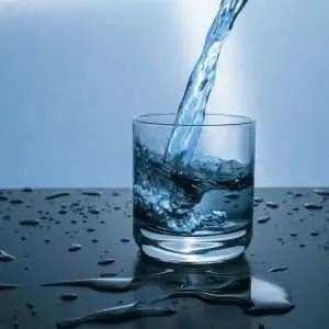 High-quality image of water being poured into a glass, illustrating hydration and purity.